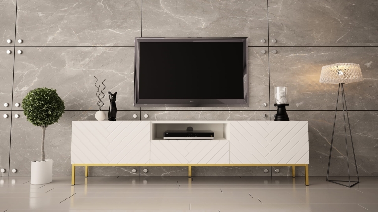 Biała szafka RTV na nóżkach ze złotym stelażem.