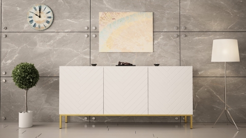 Biała komoda w połysku z frezowanymi frontami jodełka na złotym stelażu.